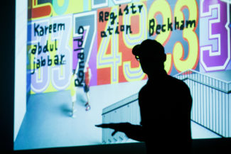 Schattenmann auf der Tÿpo St. Gallen: Andreas Uebele setzte den furiosen Schlusspunkt, im Hintergrund: Blick auf farbenfrohe „Wohlfühlwandbilder“ mit Zahlen-Buchstaben-Ornamentik aus der Welt des Sports fürs Adidas-Fitnessstudio.
