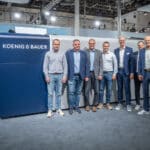 Das Management-Team von Silber Druck sowie Koenig & Bauer vor der neuen Rapida 106 X auf dem Drupa-Stand von Koenig & Bauer in Düsseldorf.