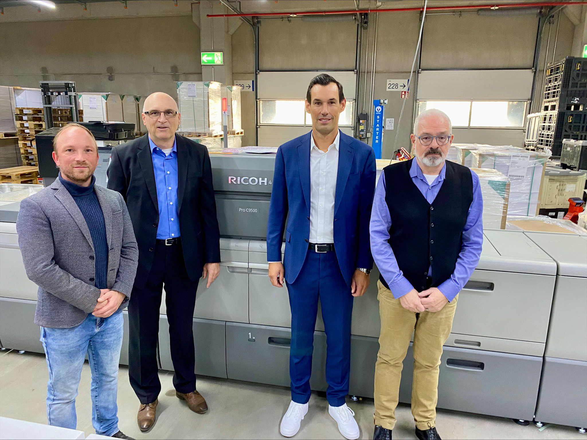Vor einer der neuen Ricoh-Druckmaschinen (von links): Kay Wissendorf (Einkaufsleiter Zeitfracht Medien), Hans Dietmar Haupt (Sales Spezialist, Ricoh), Simon Fastenau (Senior Sales Specialist, Ricoh), Joachim Kühn (CPI).